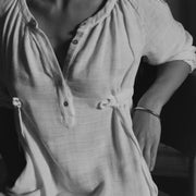 Close-up detail of The Lydia cotton-bamboo dress, gathered neckline and tie waist, black and white editorial