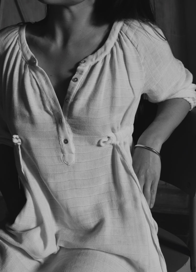 Close-up detail of The Lydia cotton-bamboo dress, gathered neckline and tie waist, black and white editorial