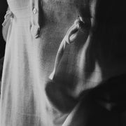 Close-up of The Lydia cotton-bamboo dress fabric texture and side tie detail, black and white editorial
