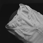 The Lydia cotton-bamboo dress folded with Salvē label visible, black and white product detail shot