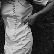 Close-up of The Thelma cotton dress showing full-length button closure detail, black and white editorial