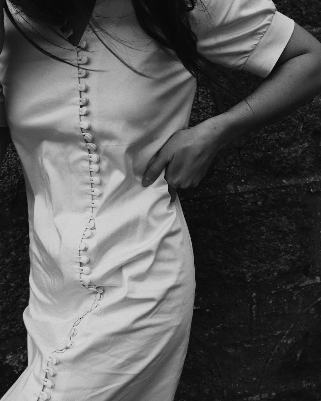 Close-up of The Thelma cotton dress showing full-length button closure detail, black and white editorial